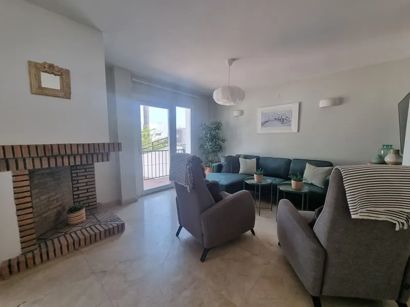 Living room with fireplace and door to the terrace